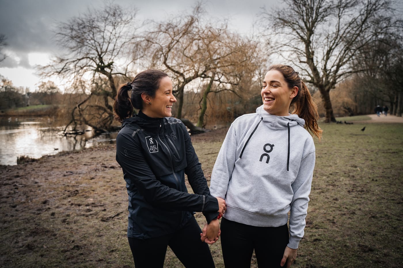 Bruna and Fabi smiling outdoors by a lake